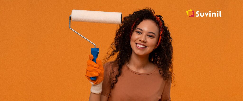 Mulher negra com rolo de pintar na mão